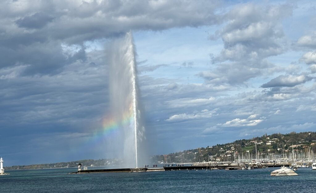 a water spouting from a fountain with Jet d'Eau in the background