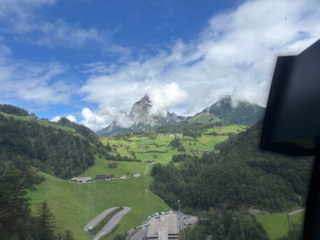 a view of a green valley with a road and mountains