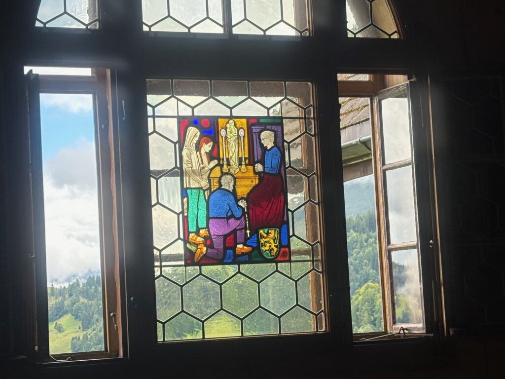 a stained glass window with a landscape in the background