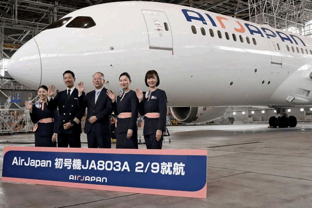 a group of people waving in front of a large white airplane