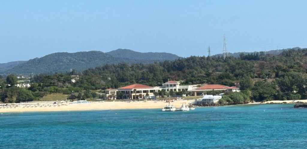 a building on a beach with boats in the water