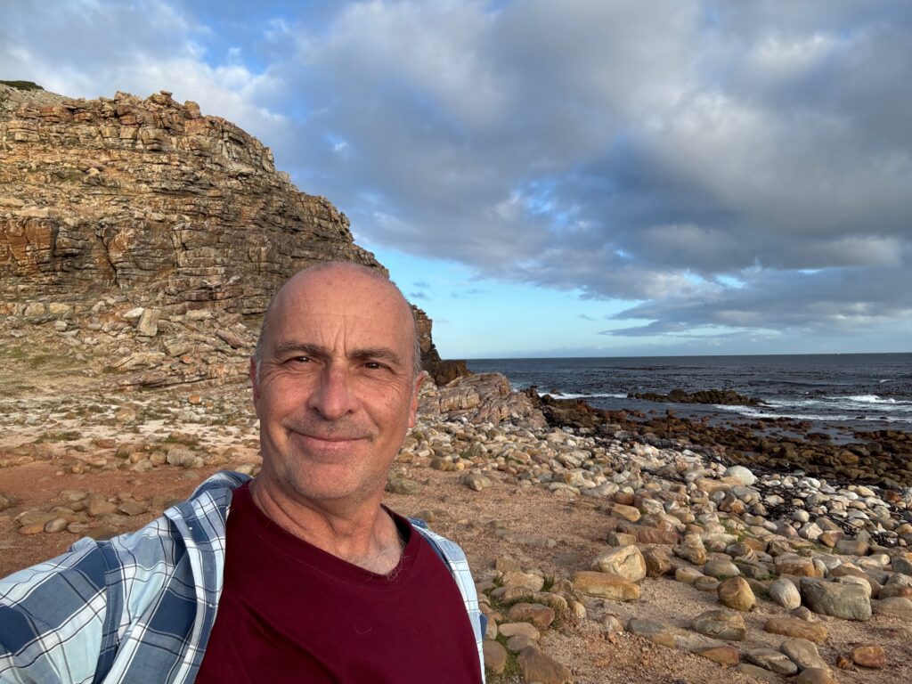 a man taking a selfie on a rocky beach