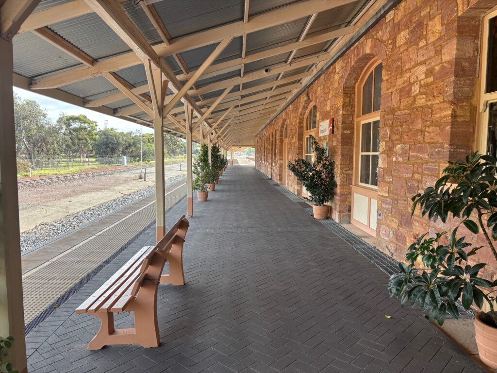 a brick building with a bench and plants