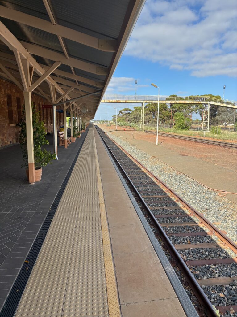 a train station with a platform and a building