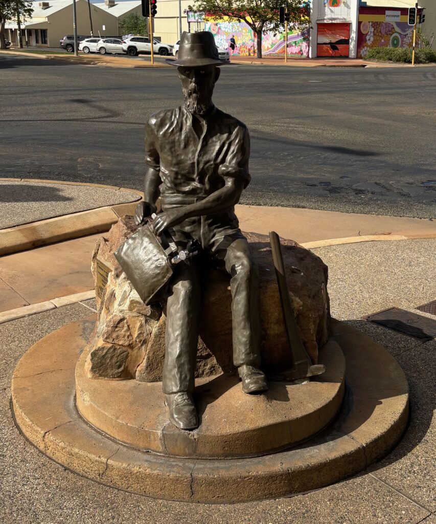a statue of a man sitting on a rock