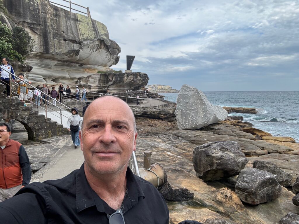 a man taking a selfie on a rocky beach