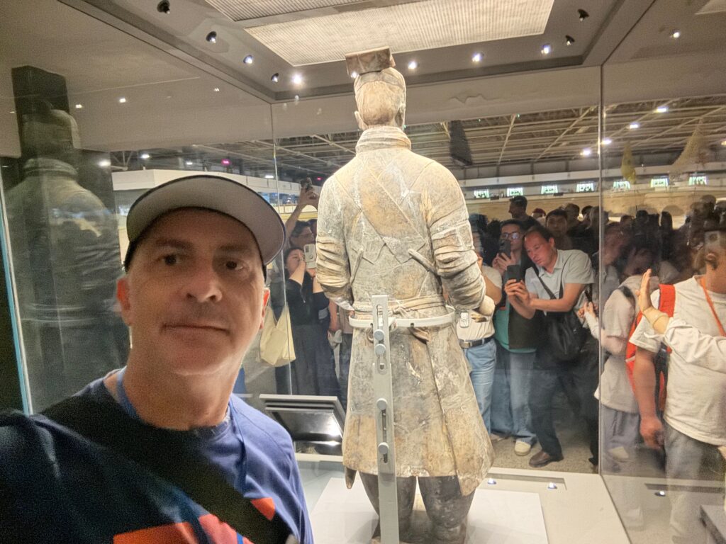 a man taking a selfie in front of a statue