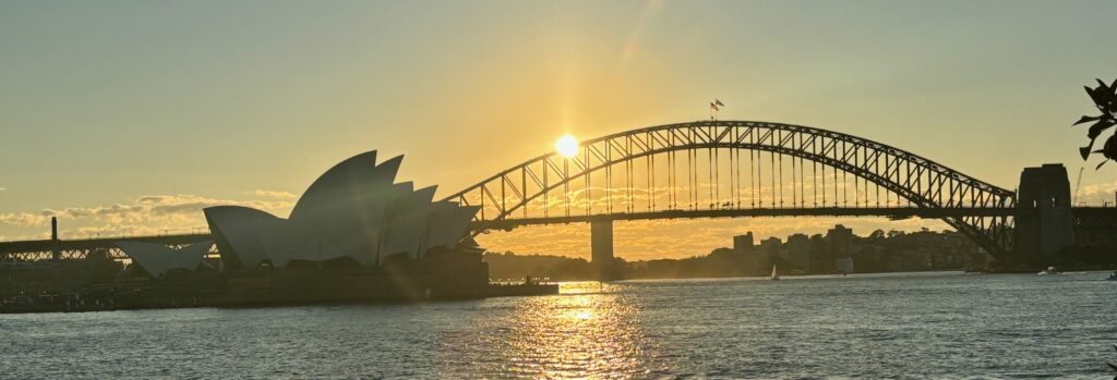 a bridge over water with a building and a bridge in the background