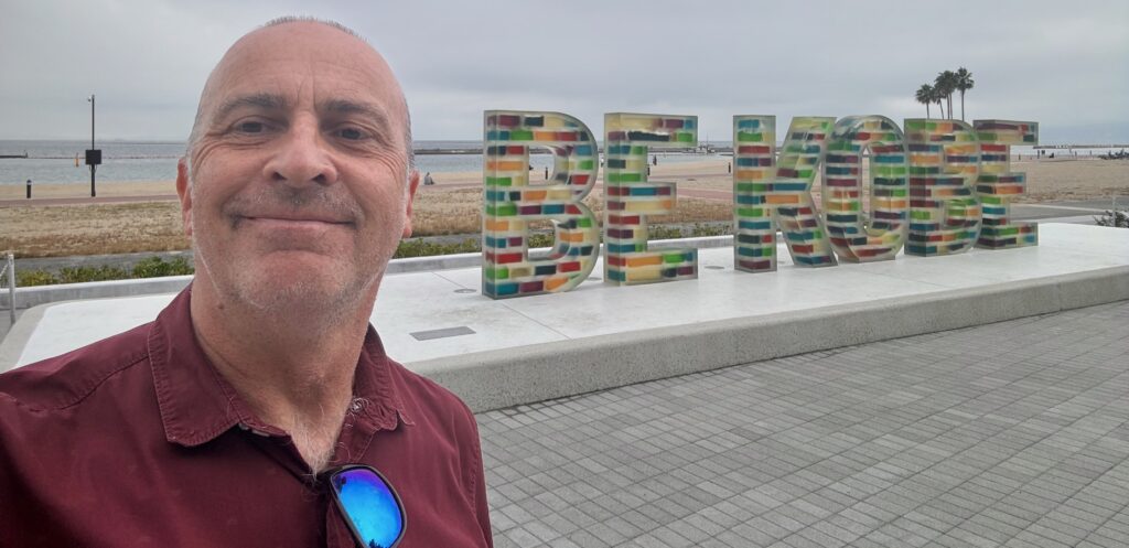 a man taking a selfie in front of a sign