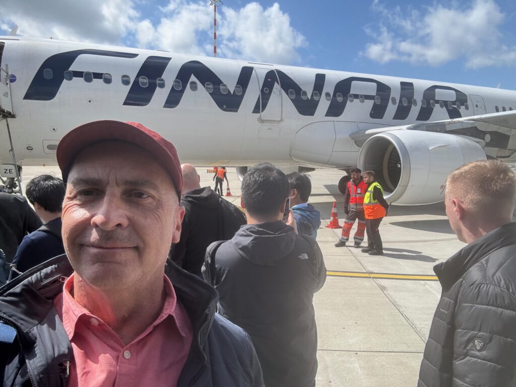 a man taking a selfie in front of a plane