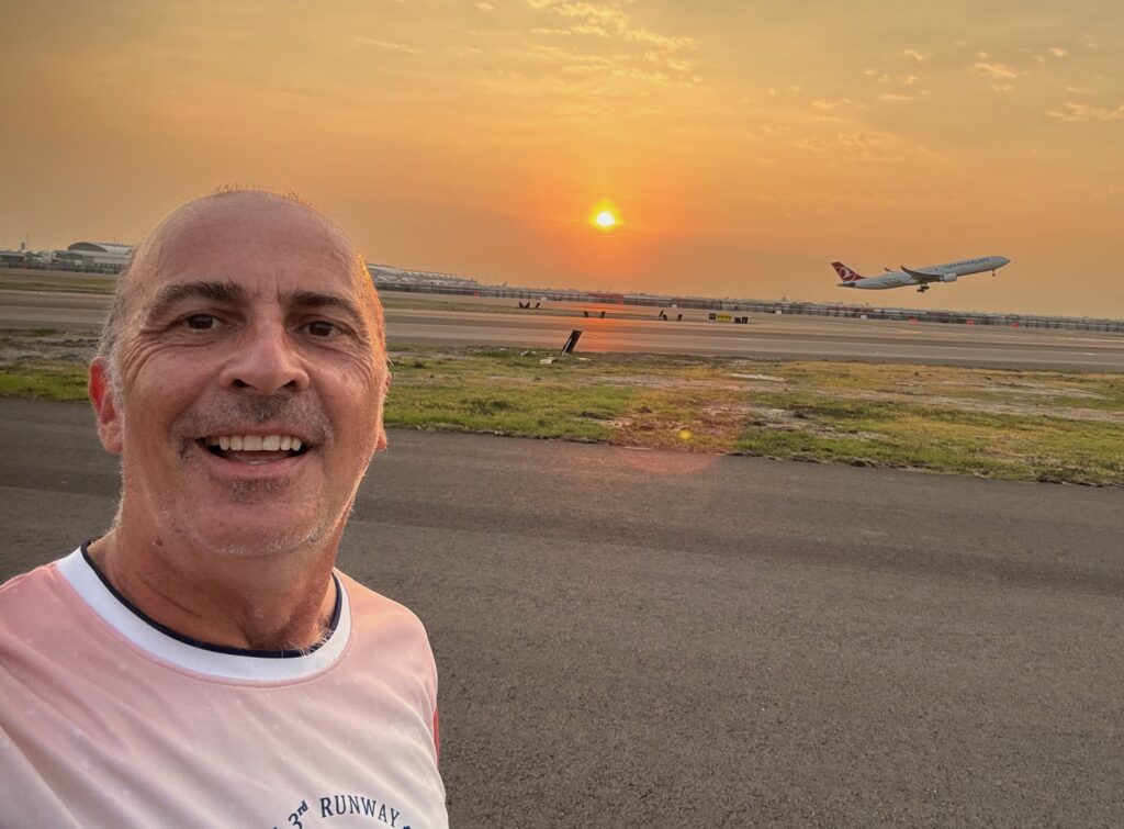 a man taking a selfie with an airplane in the background