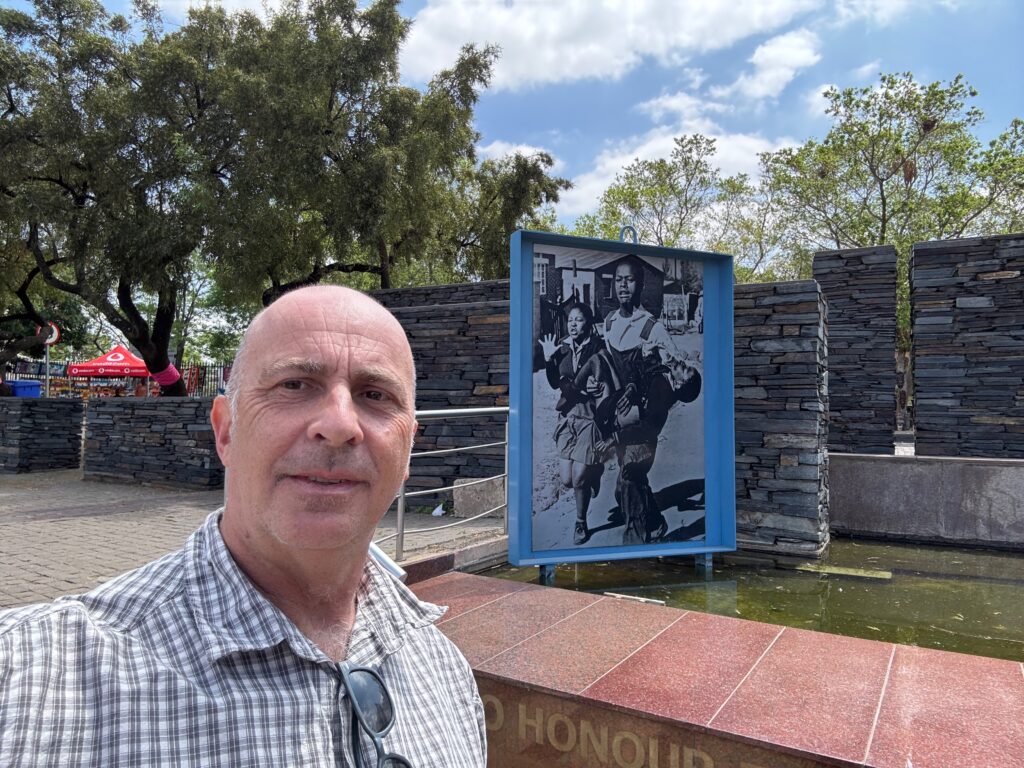 a man taking a selfie in front of a sign