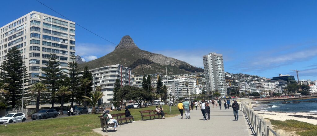 a group of people walking on a path with a mountain in the background
