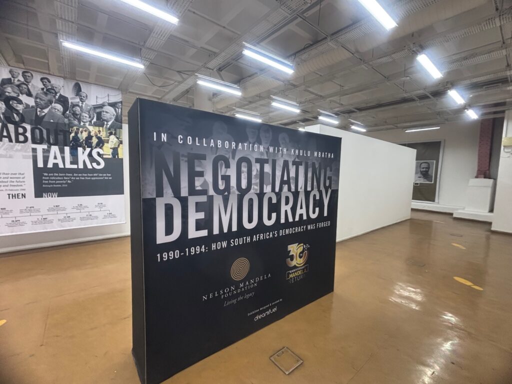 a large black and white sign in a room with ceiling lights