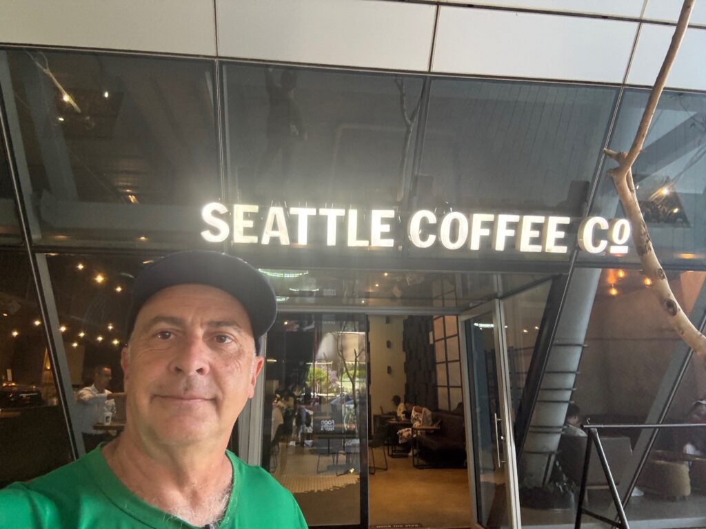 a man in a hat standing in front of a building