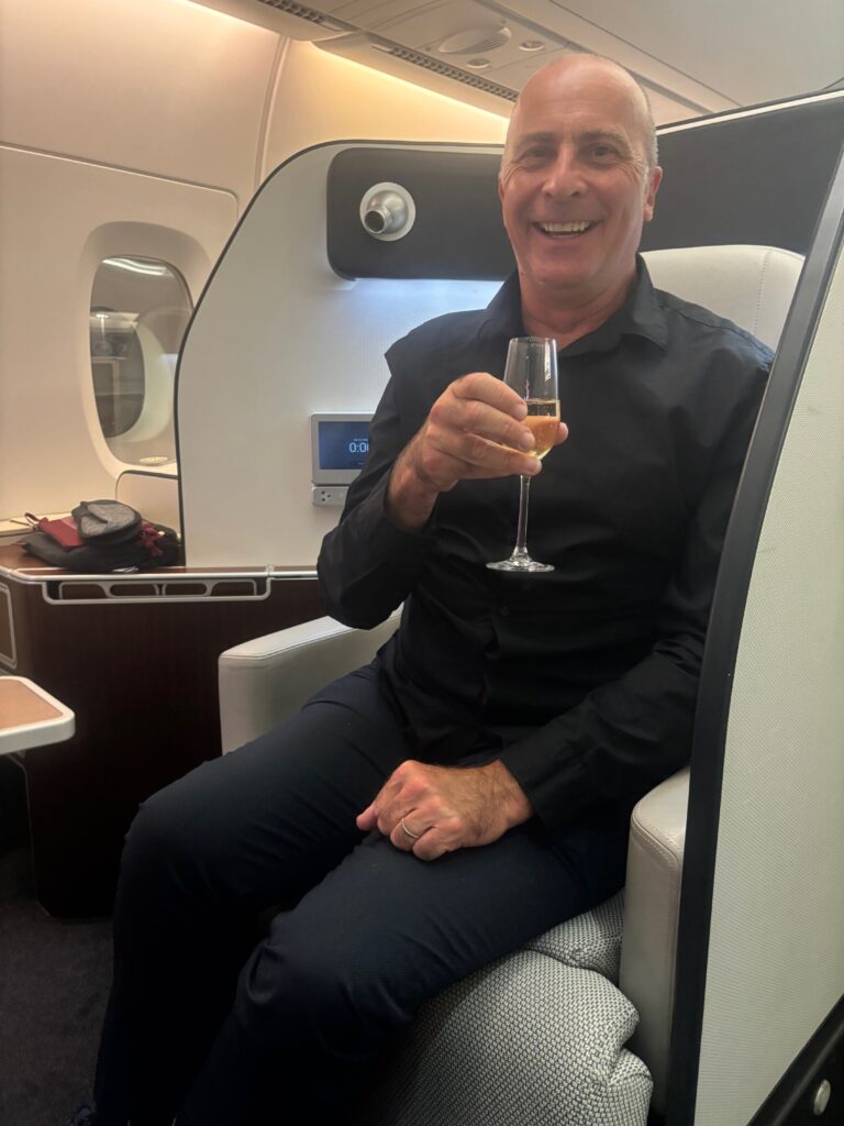 a man sitting in a chair holding a glass of champagne