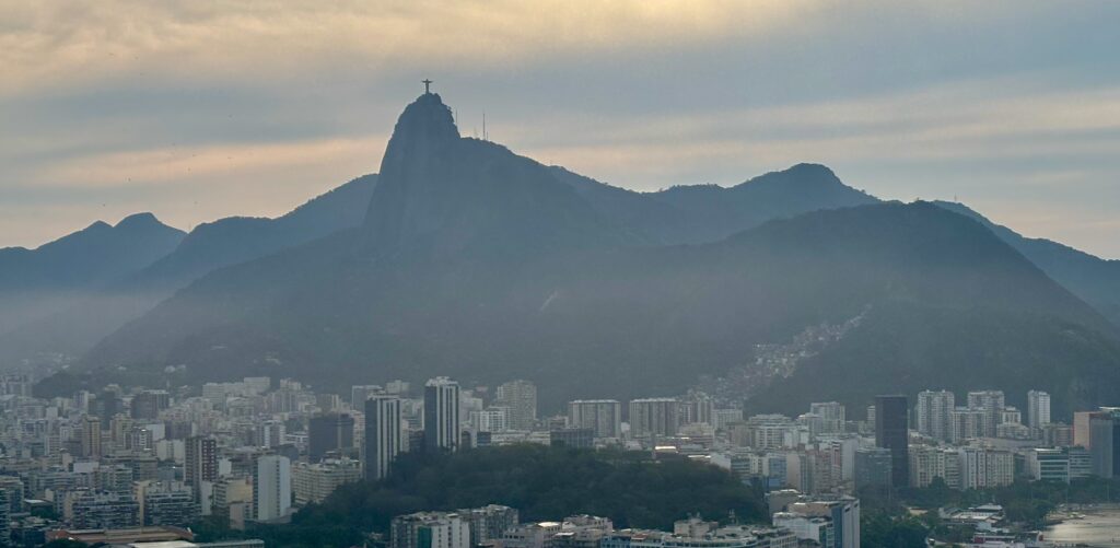 a city with mountains and a statue on top