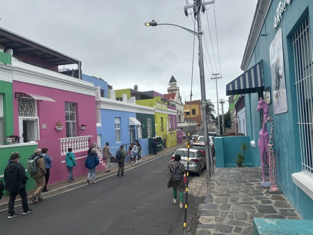 a group of people walking down a street with colorful buildings