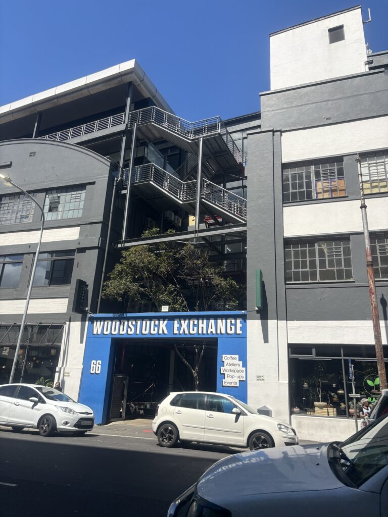 a building with a blue sign and a tree