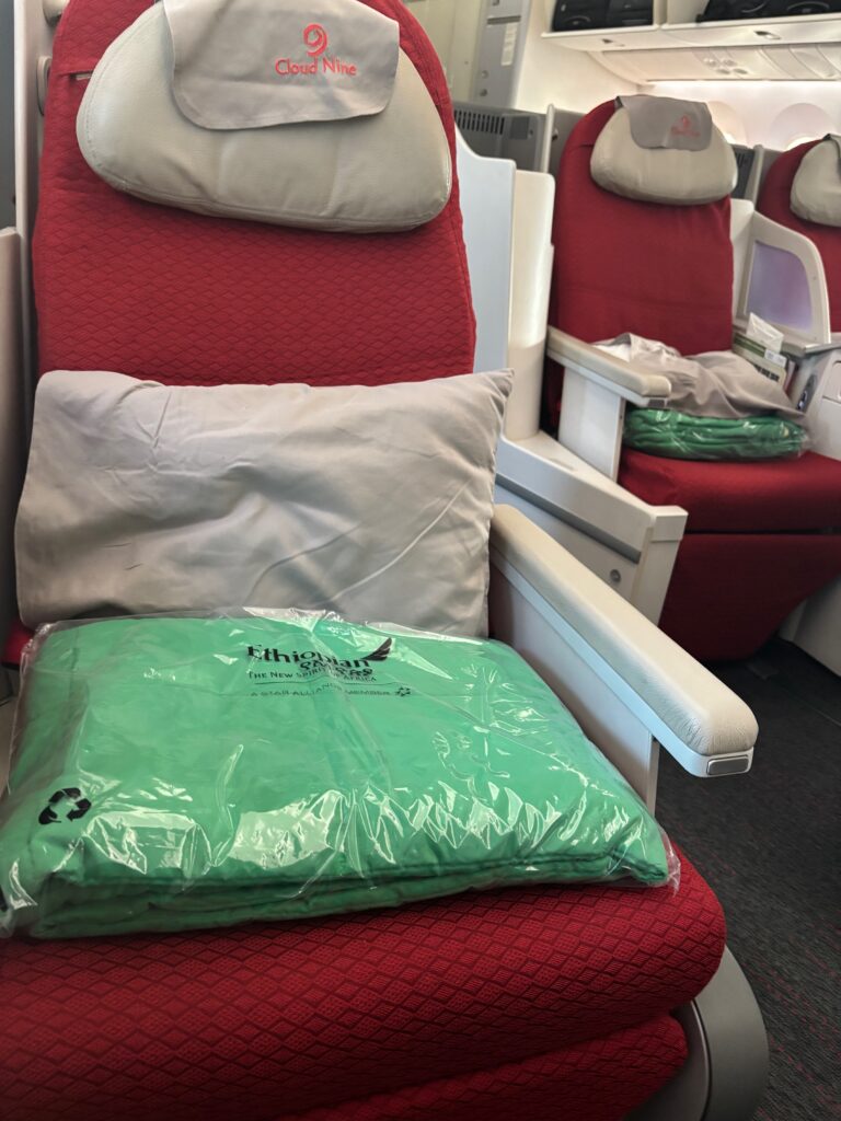 Un banco con un cojín verde y una bolsa verde encima.