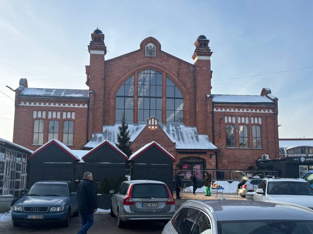a building with a large arched window and a group of cars parked in front of it