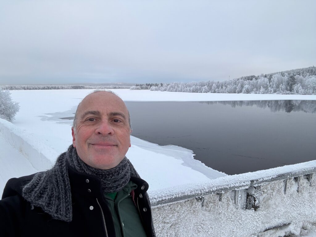 a man taking a selfie in front of a lake