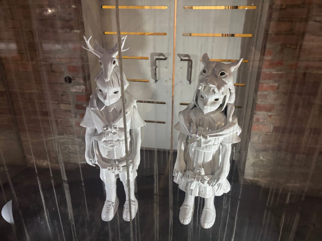a couple of white statues in front of a glass door