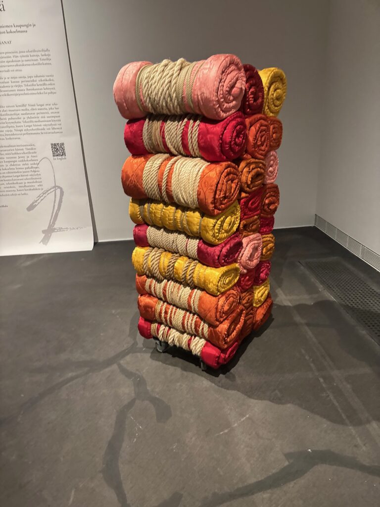 a stack of colorful rolled up blankets