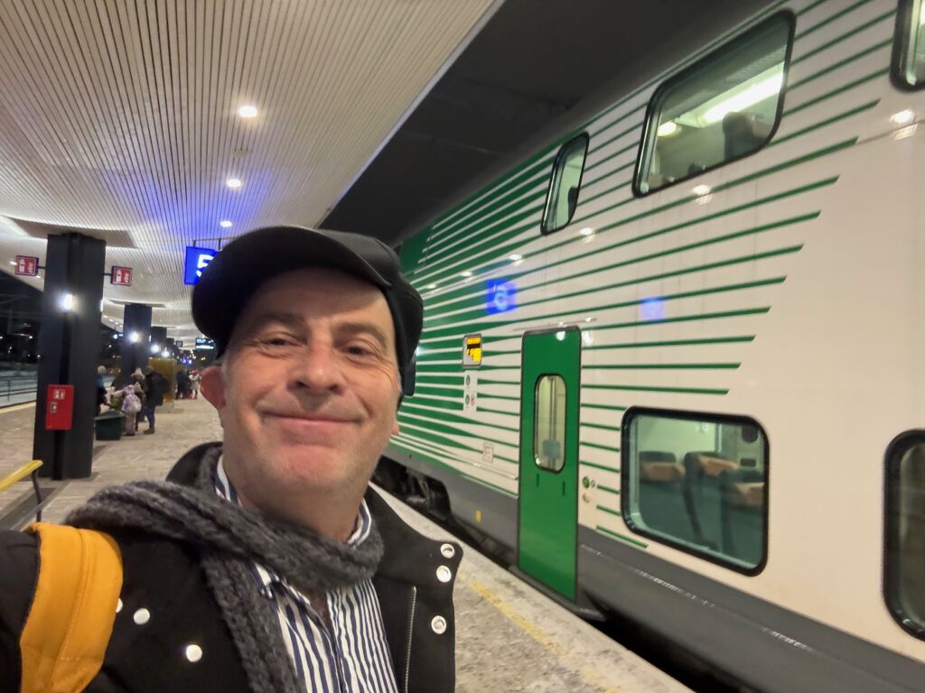 a man taking a selfie in front of a train