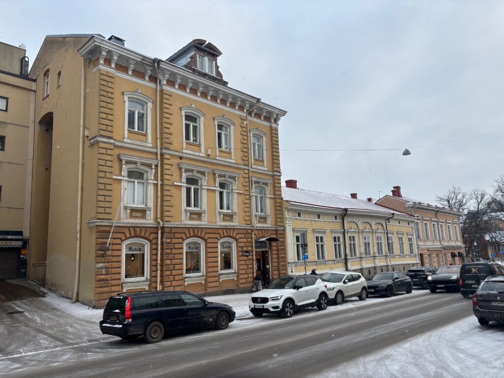 cars parked cars on a street in front of a building