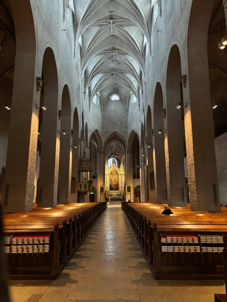 a church with many pews and a painting on the ceiling