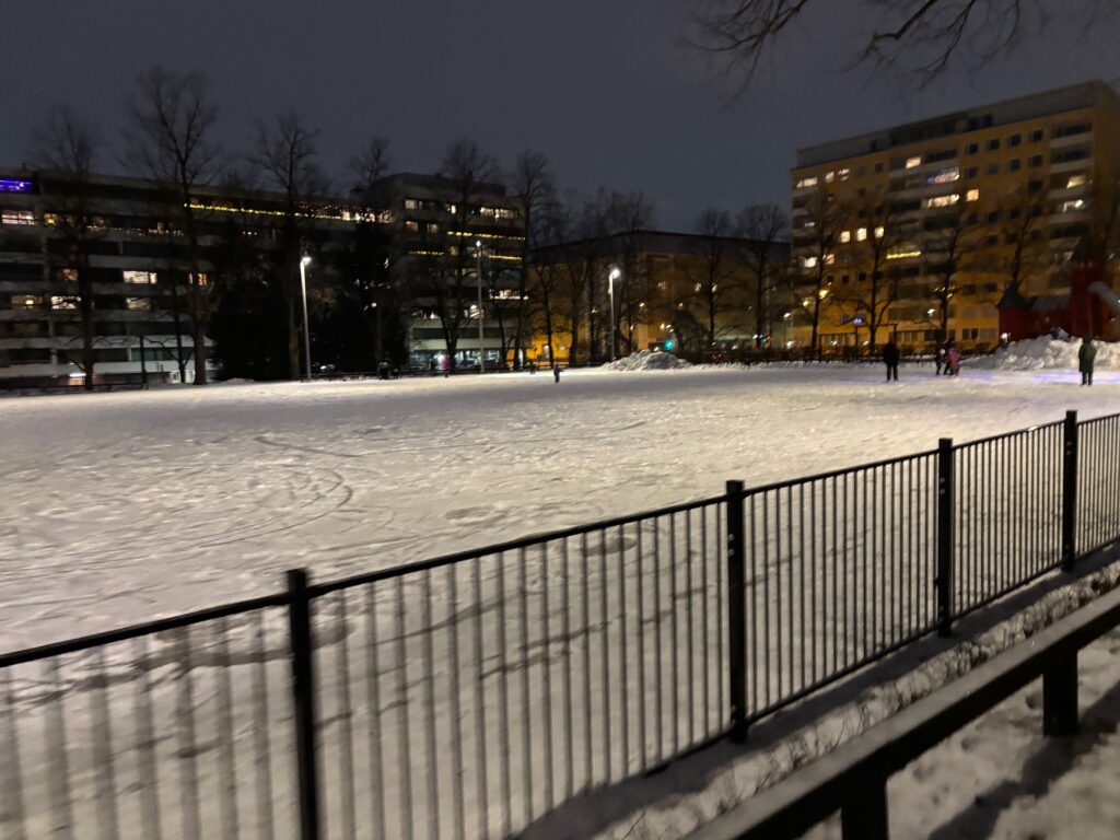 a snow covered ground with buildings in the background