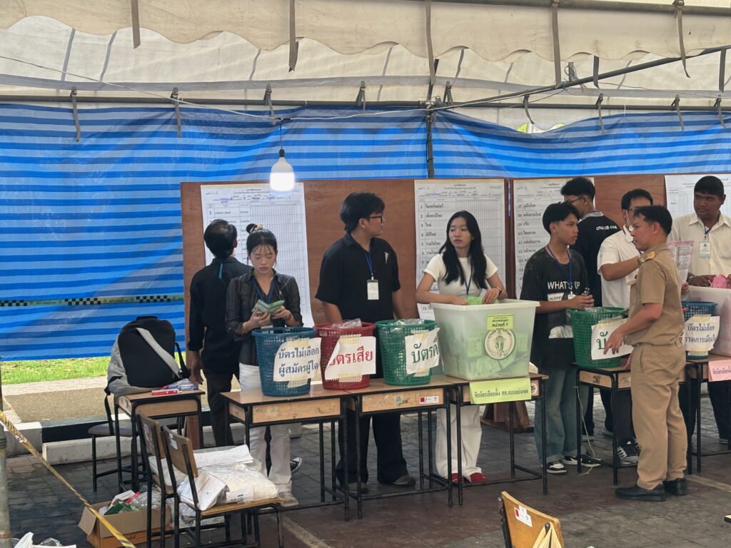 a group of people standing in a line at tables with baskets