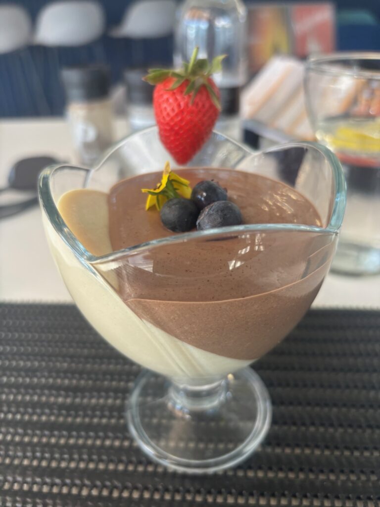 a dessert in a glass bowl with a strawberry on top