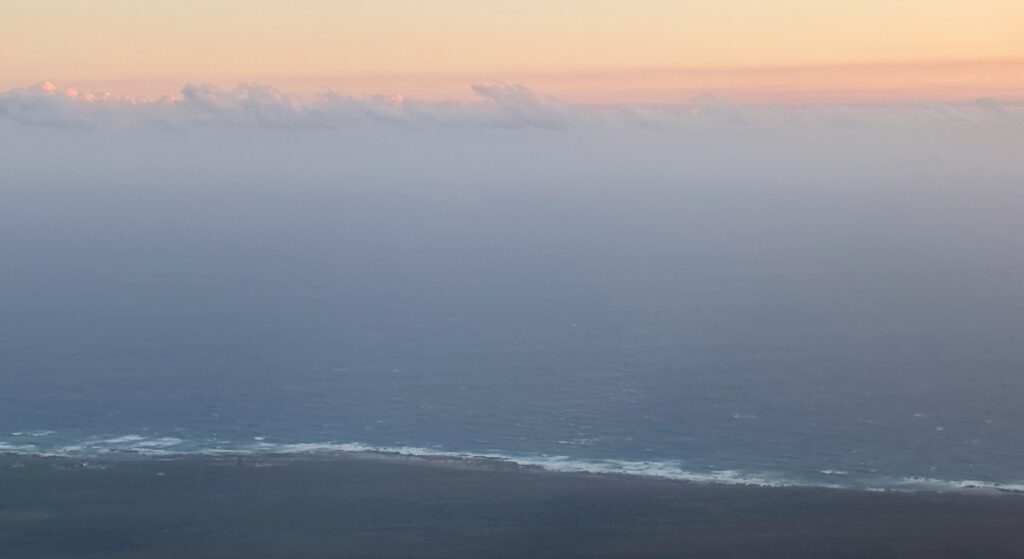 a body of water with clouds in the sky