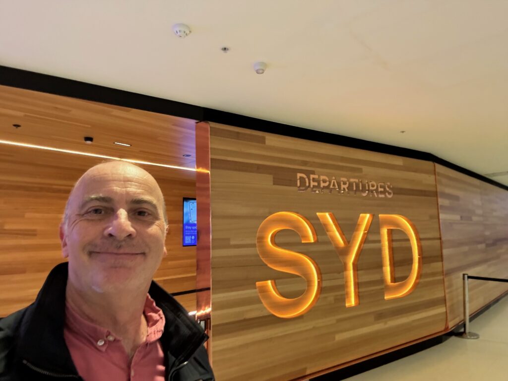 a man smiling in front of a sign