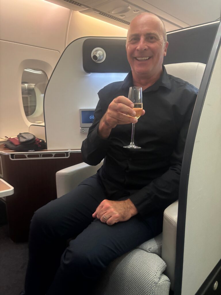 Un hombre sentado en una silla sosteniendo una copa de vino.