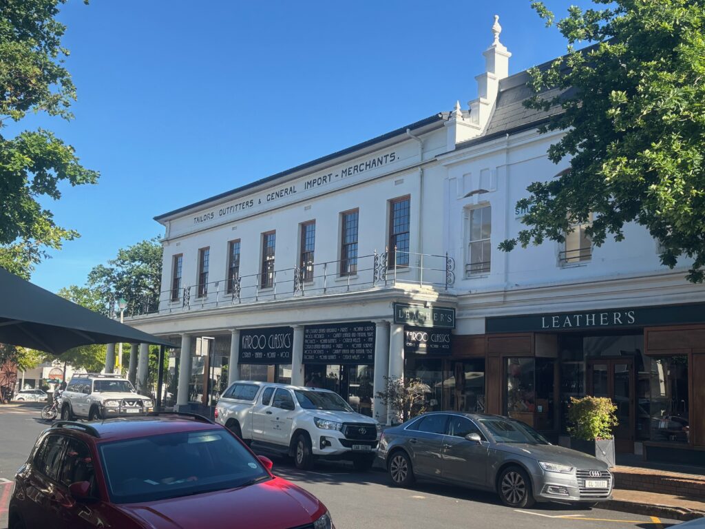 a white building with cars parked on the side of the road