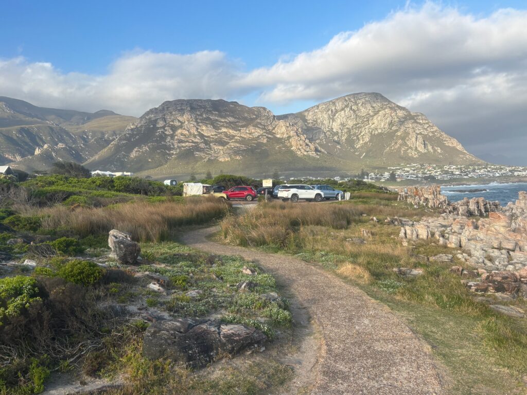 a dirt road with cars parked on it