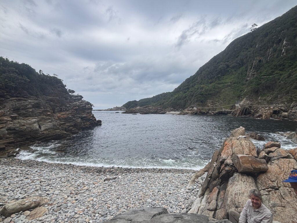 a man sitting on a rocky beach