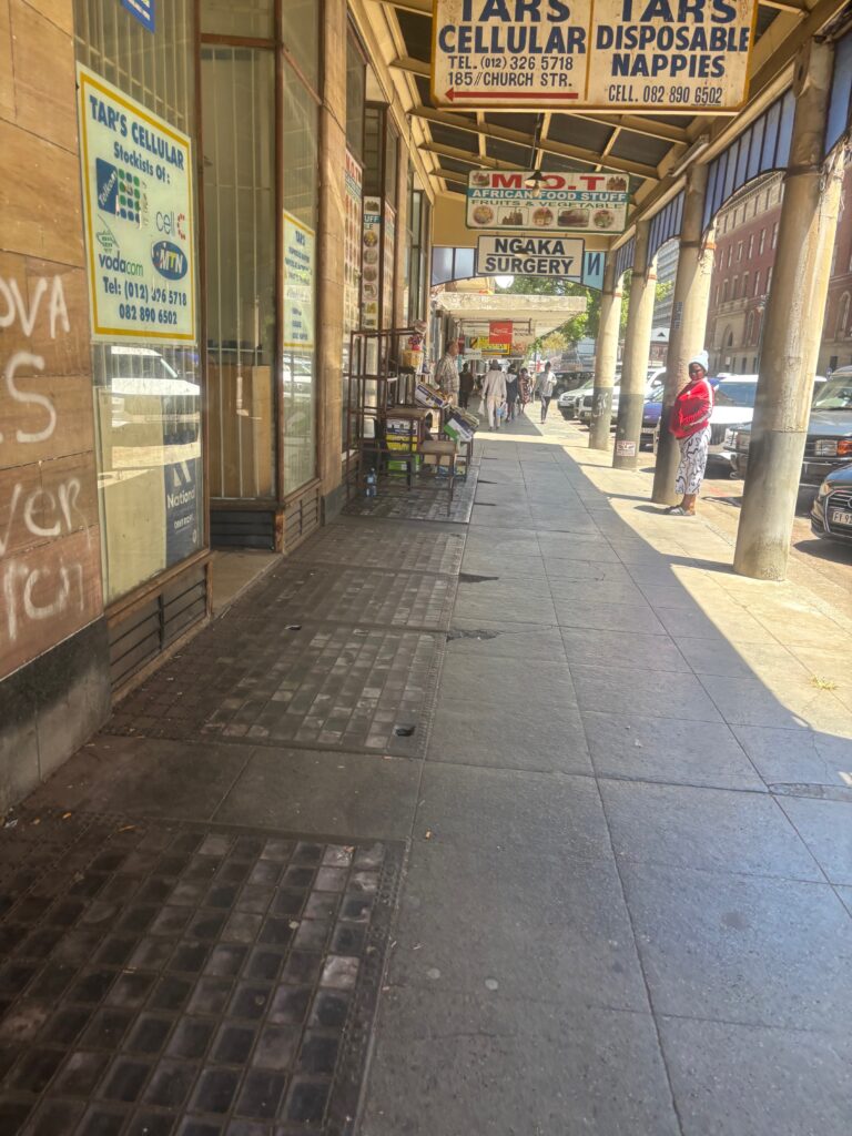 a sidewalk with a storefront