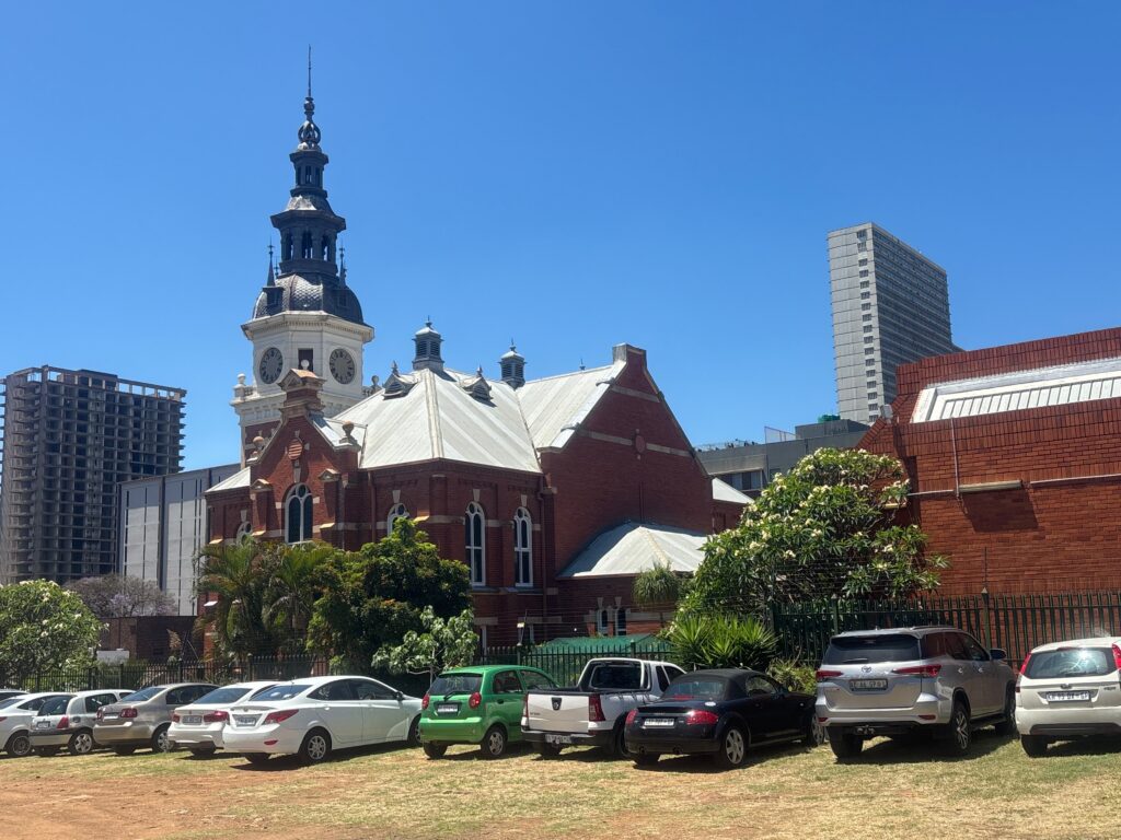 a building with a tower and cars parked in front of it