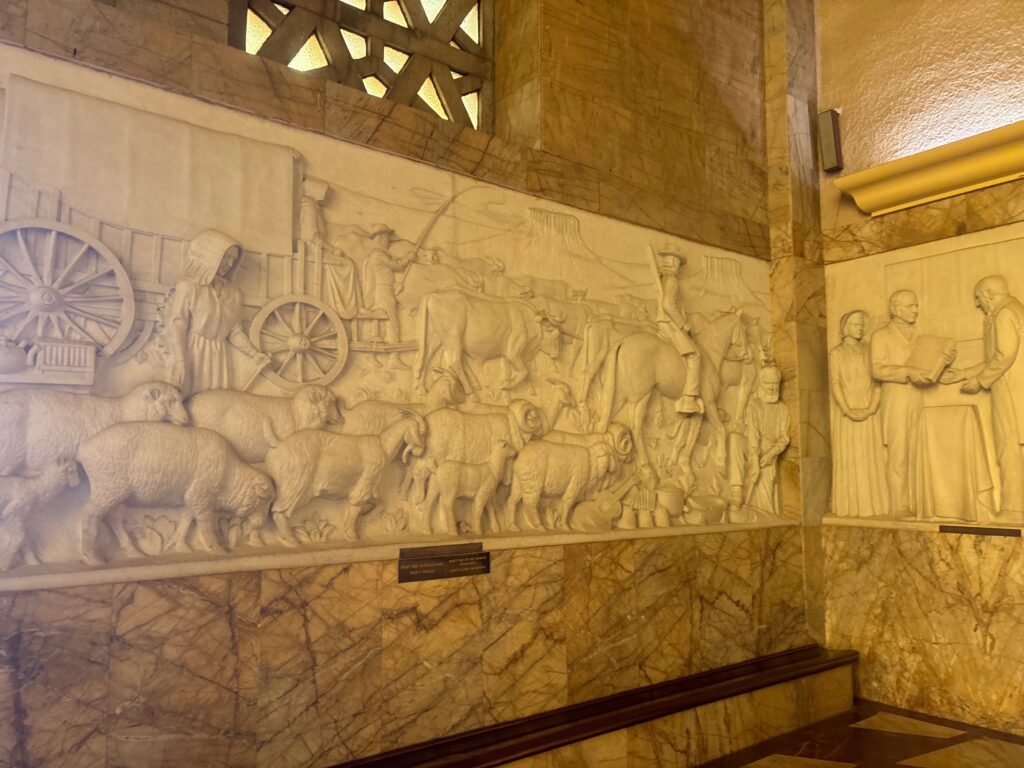 a stone wall with a relief of animals and people